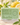 Gros plan d’un savon de Marseille verveine-citron couvert de gouttelettes et de mousse, citrons flous en arrière-plan
