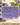 Gros plan d’un savon de Marseille violette avec mousse et gouttelettes, violettes et feuilles floues en arrière-plan
